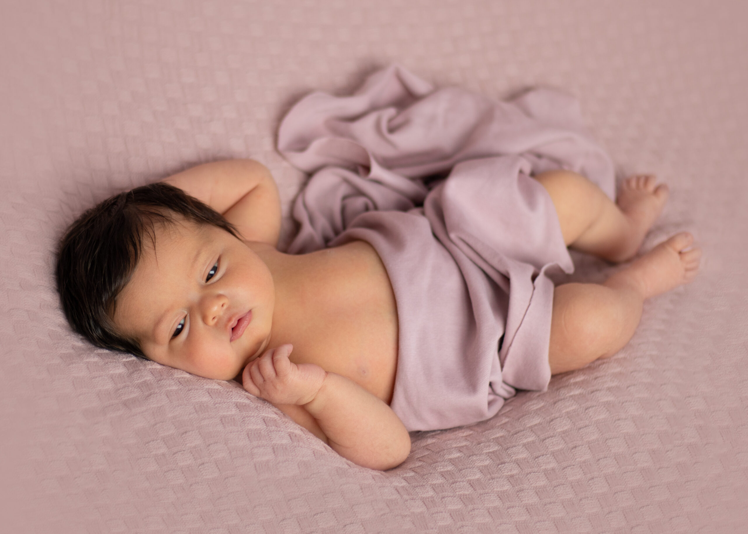 Neugeborenes Mädchen auf rosarotem Hintergrund